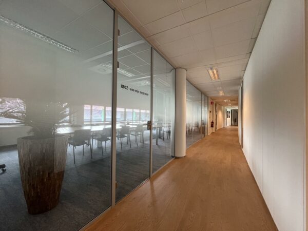Lichte kantoorruimte met een glazen vergaderruimte aan de linkerzijde in het gebouw Sparrenheuvel.