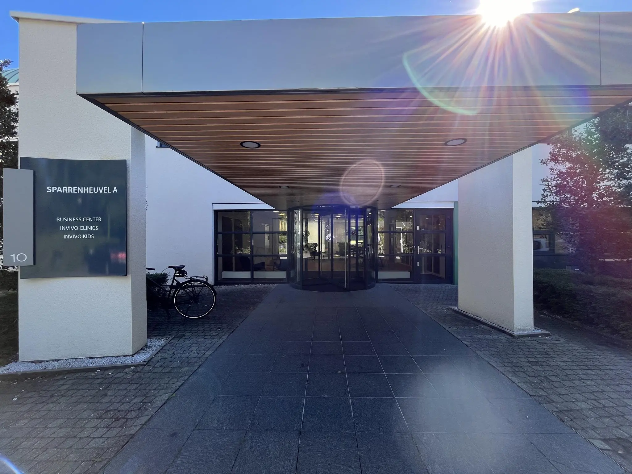 Ingang van gebouw Sparrenheuvel A met bewegwijzering naar Business Center, Invivo Clinics en Invivo Kids.