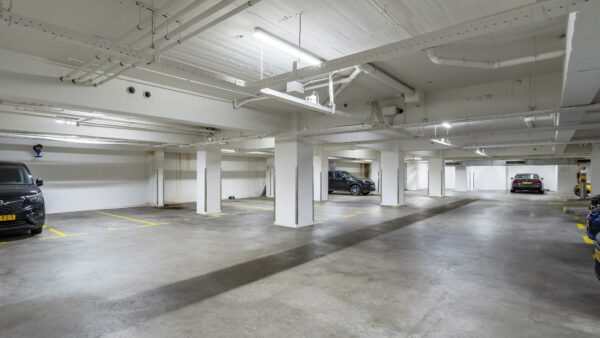 Ondergrondse parkeergarage aan de Coolsingel met enkele geparkeerde auto's en betonnen pilaren.