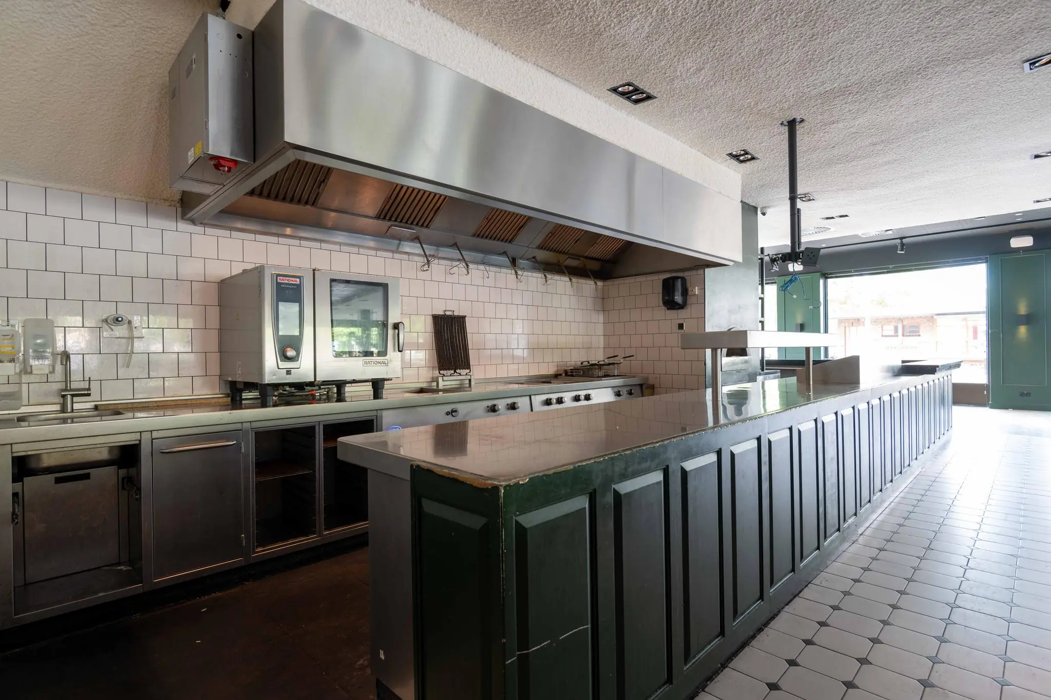 Professionele horecakeuken met rvs-apparatuur en een lange uitgiftebalie aan het Stadionplein.