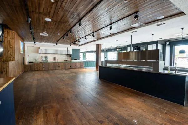 Leegstaand horecapand aan het Stadionplein met houten vloer, open keuken en moderne afwerkingsdetails.