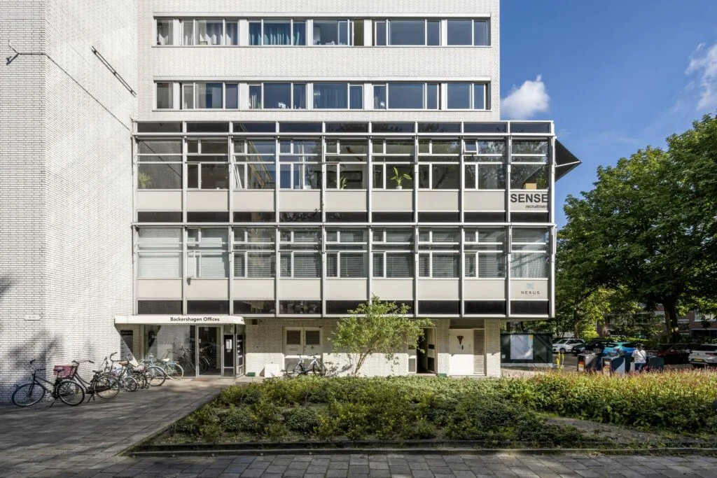 Vooraanzicht van het kantoorgebouw Backershagen Offices met fietsenrek en de gevel van SENSE Recruitment.