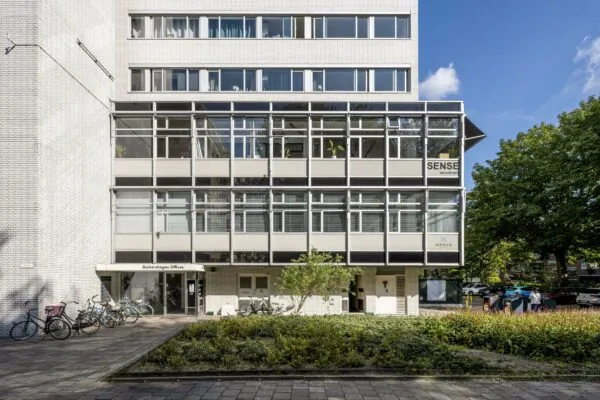 Vooraanzicht van het kantoorgebouw Backershagen Offices met fietsenrek en de gevel van SENSE Recruitment.