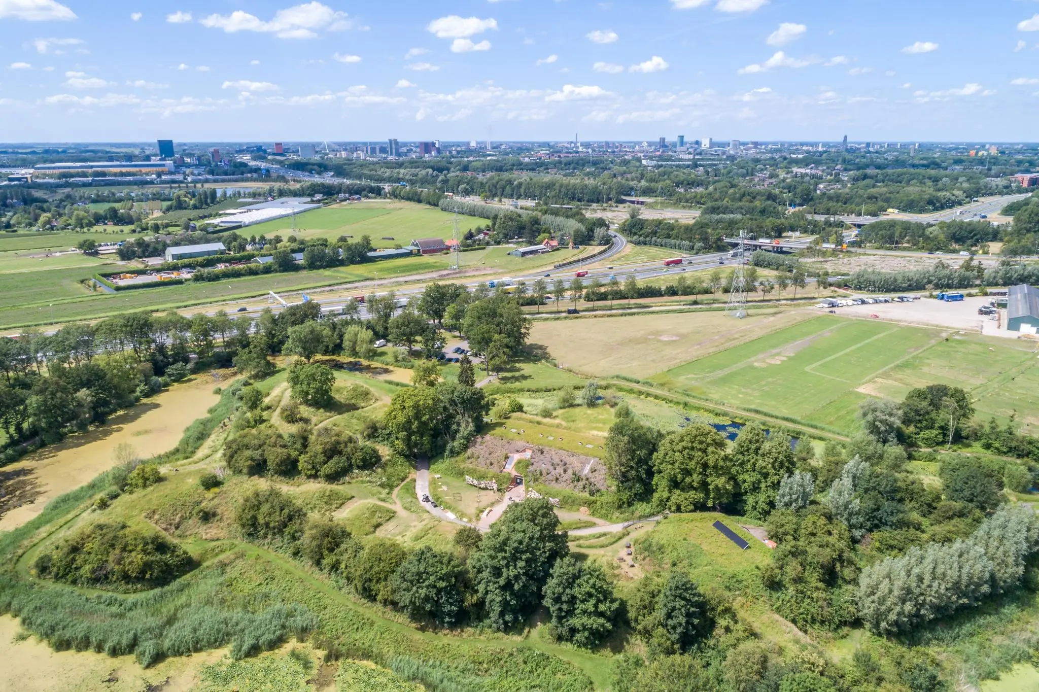 Luchtfoto van Fort bij Vijfhuizen aan de Fortweg, omgeven door groen en gelegen nabij snelwegen en een stedelijke omgeving.