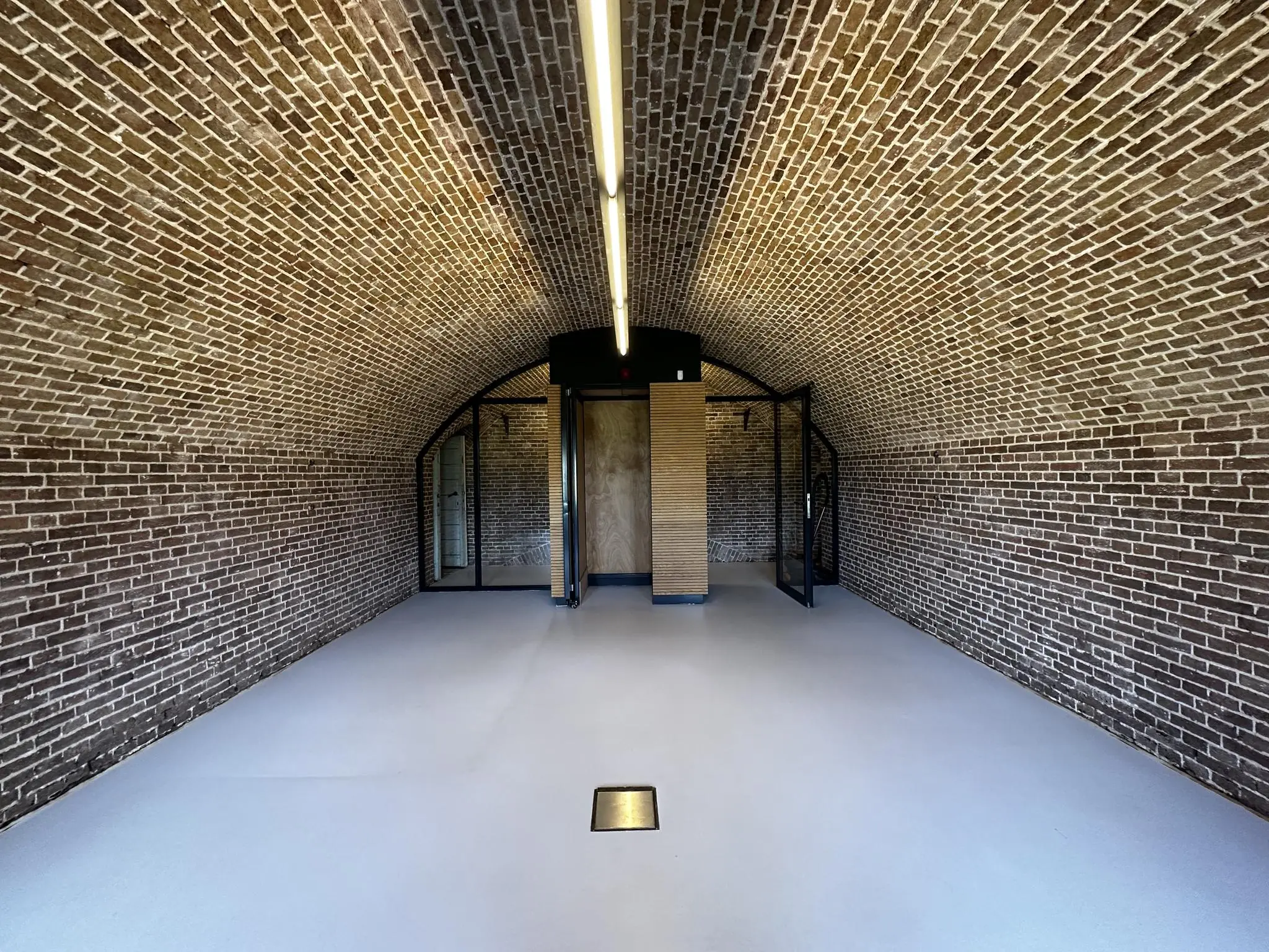 Gang met bakstenen tongewelfplafond en glazen deuren in Fortweg.