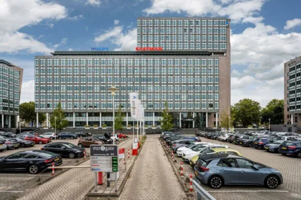 Kantoorcomplex Eurogate aan de Watermanweg met zicht op geparkeerde auto's en de gevels van Mazars en Eastman.