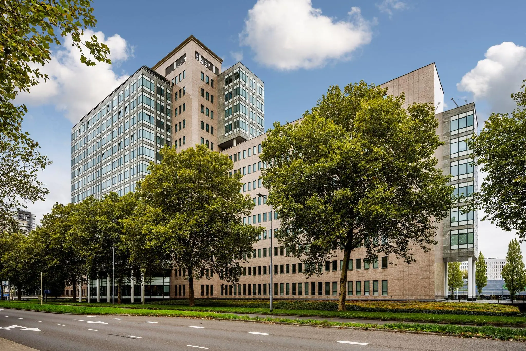 Kantoorgebouw aan de Watermanweg in Rotterdam, omgeven door bomen en gelegen langs een brede weg.