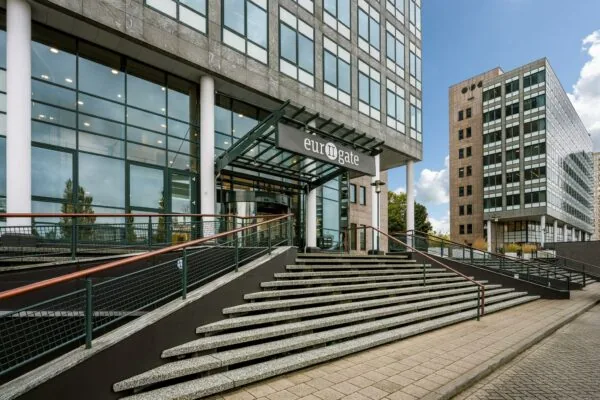 Ingang van het kantoorgebouw "Eurogate" aan de Watermanweg met brede trap en moderne gevel.