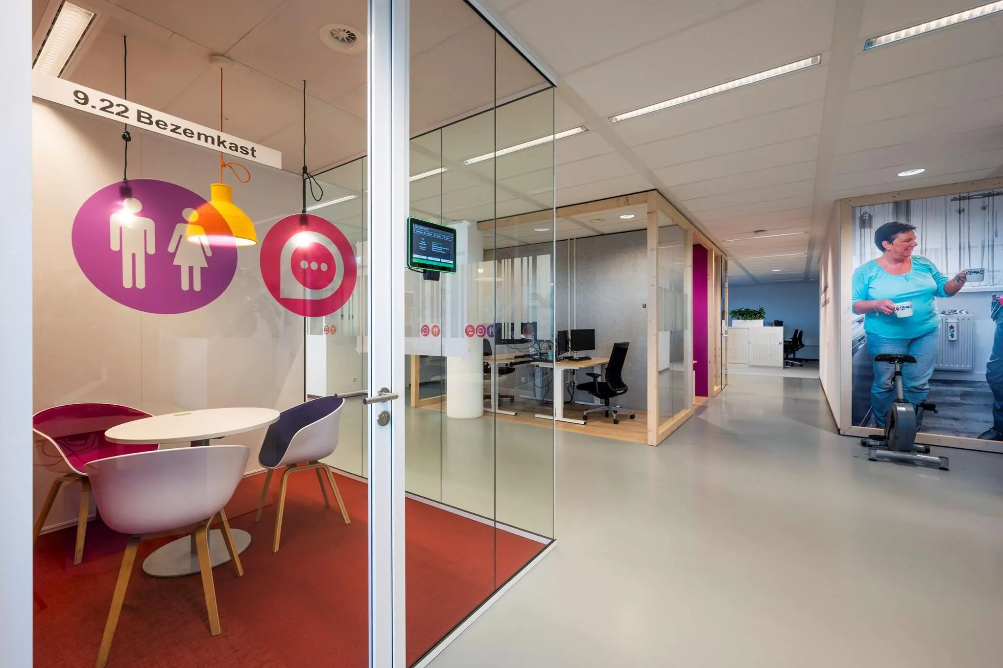 Moderne kantoorruimte aan de Watermanweg met glazen vergaderruimte, werkplekken en kleurrijke inrichting.