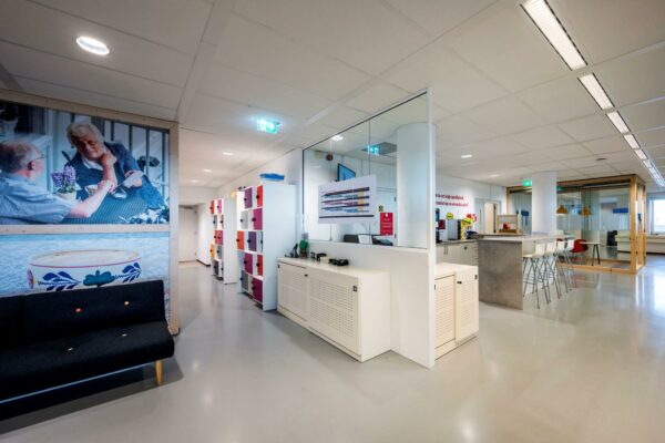 Moderne kantoorruimte aan de Watermanweg met kleurrijke lockers, zitgedeelte en open pantry.