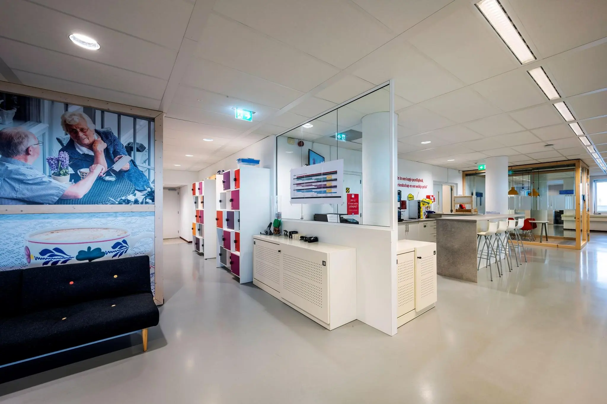 Moderne kantoorruimte aan de Watermanweg met kleurrijke lockers, zitgedeelte en open pantry.