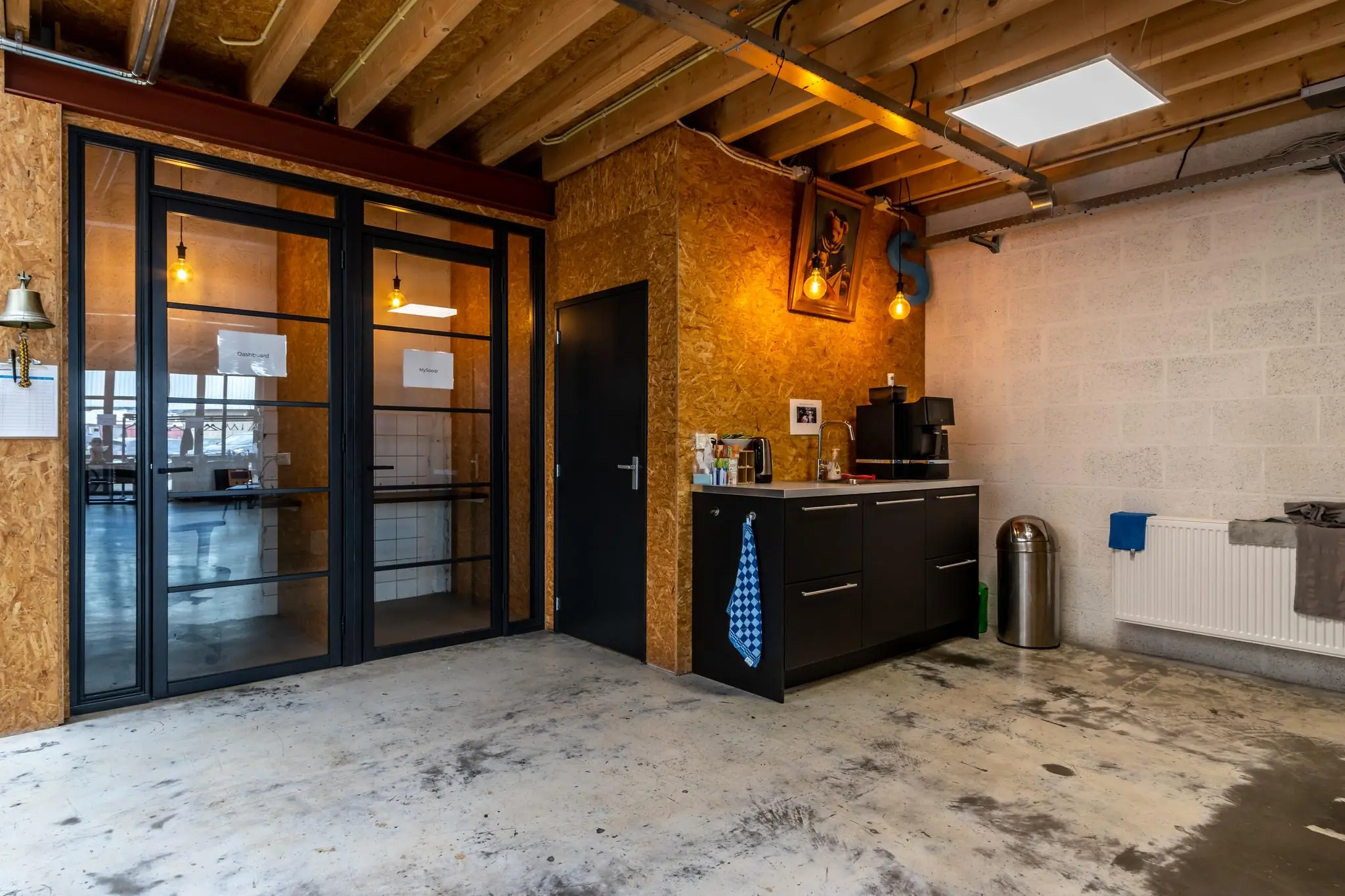 Industriële pantry in een kantoorruimte aan de Eendrachtlaan met een koffiecorner, zwarte kasten en OSB-wanden.