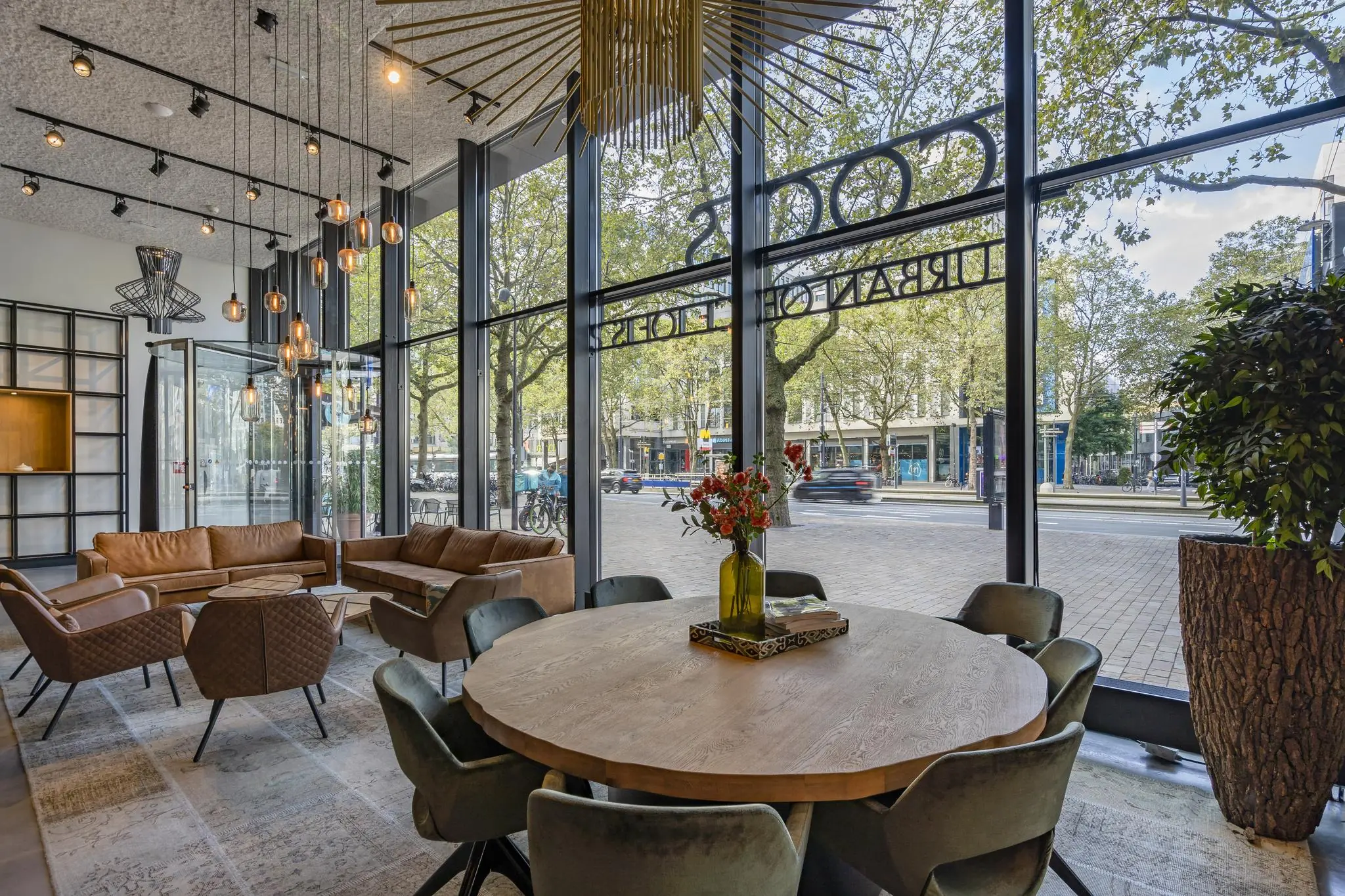 Modern ingerichte lounge met grote ramen aan de Coolsingel in Rotterdam, met zicht op de straat en comfortabele zitplaatsen.