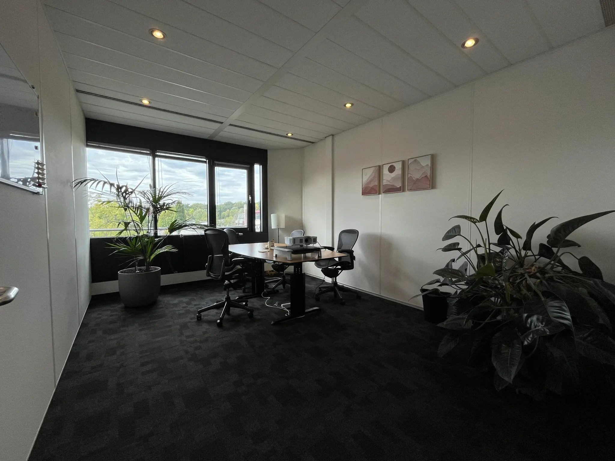 Moderne kantoorruimte aan de Wattbaan met vergadertafel, bureaustoelen, kamerplanten en veel natuurlijk licht.