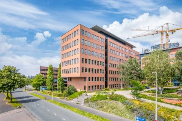 Kantoorgebouw aan de Hullenbergweg in Amsterdam met roodstenen gevel en omliggend groen.