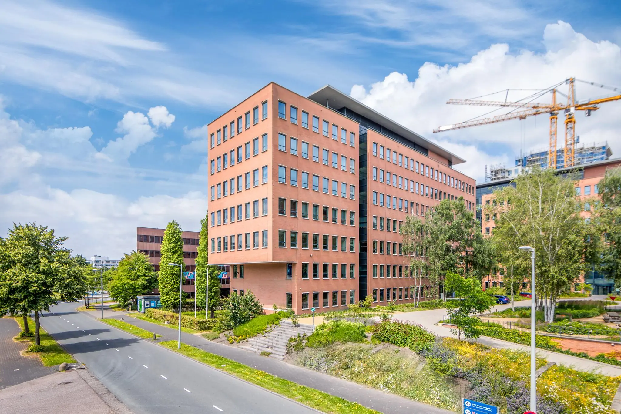 Kantoorgebouw aan de Hullenbergweg in Amsterdam met roodstenen gevel en omliggend groen.