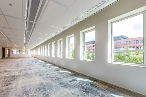Lichte, lege kantoorruimte aan de Hullenbergweg met grote ramen en systeemplafond.