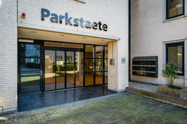Ingang van het gebouw Parkstaete aan de Amaliastraat 41 met glazen schuifdeuren en brievenbussen.