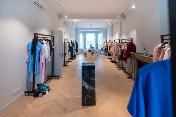 Luxe kledingwinkel aan de Hobbemastraat met rekken vol kleurrijke damesmode en een strak, modern interieur.