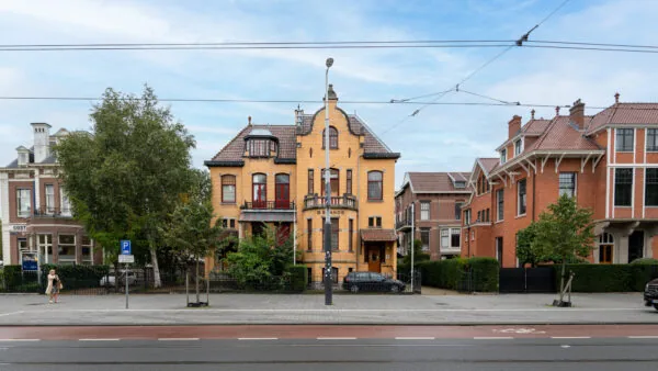 Gele bakstenen villa met het opschrift "Brands" aan de Hobbemastraat, geflankeerd door statige herenhuizen.