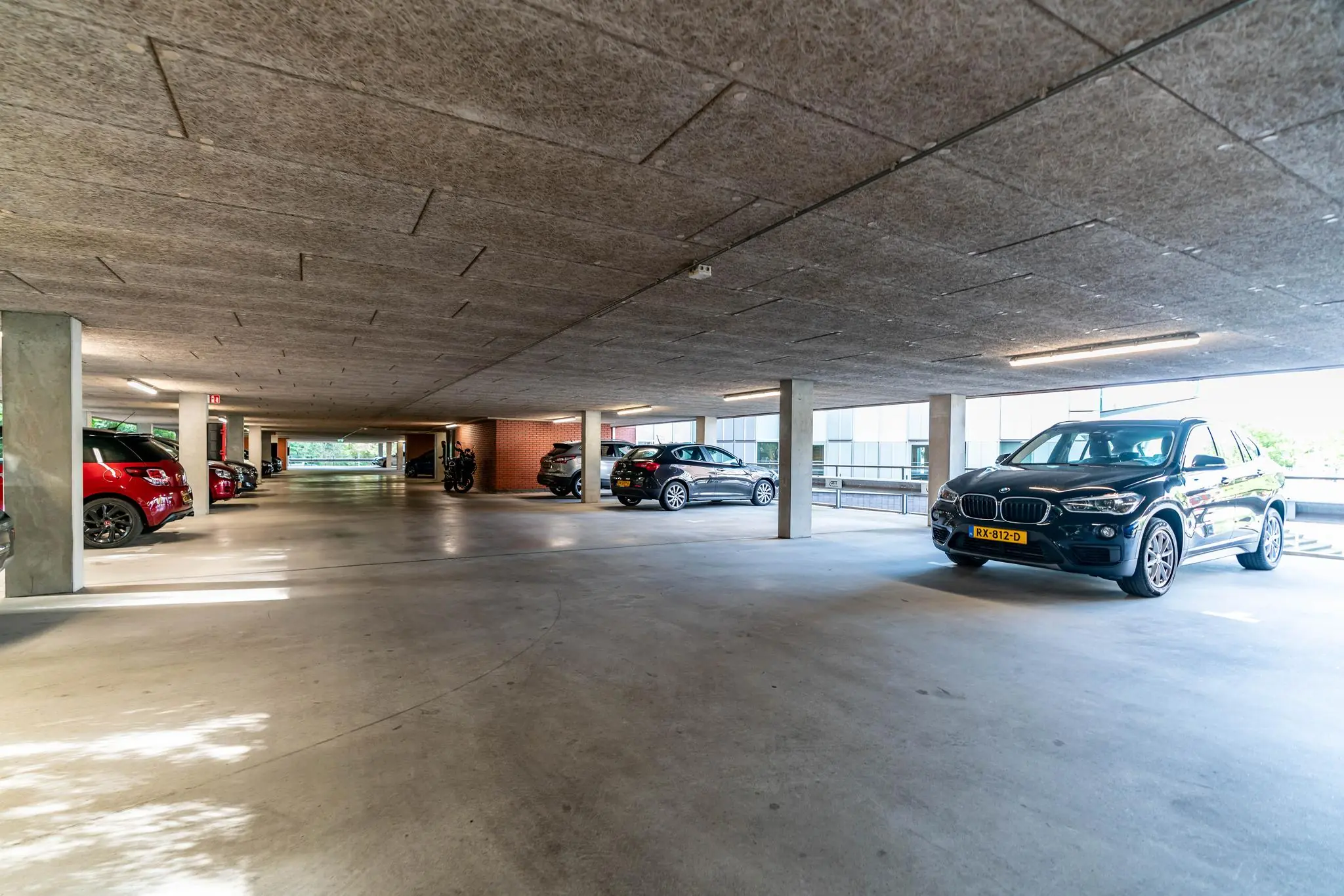 Overdekte parkeergarage met geparkeerde auto's bij Delftechpark in Delft.