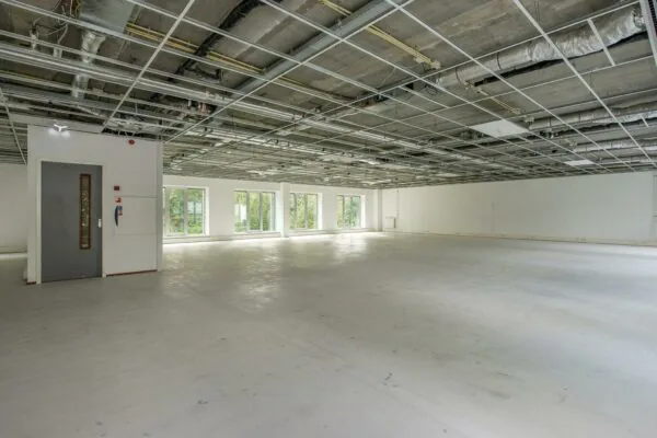 Leeg kantoorpand in Delftechpark met open systeemplafond en grote ramen.