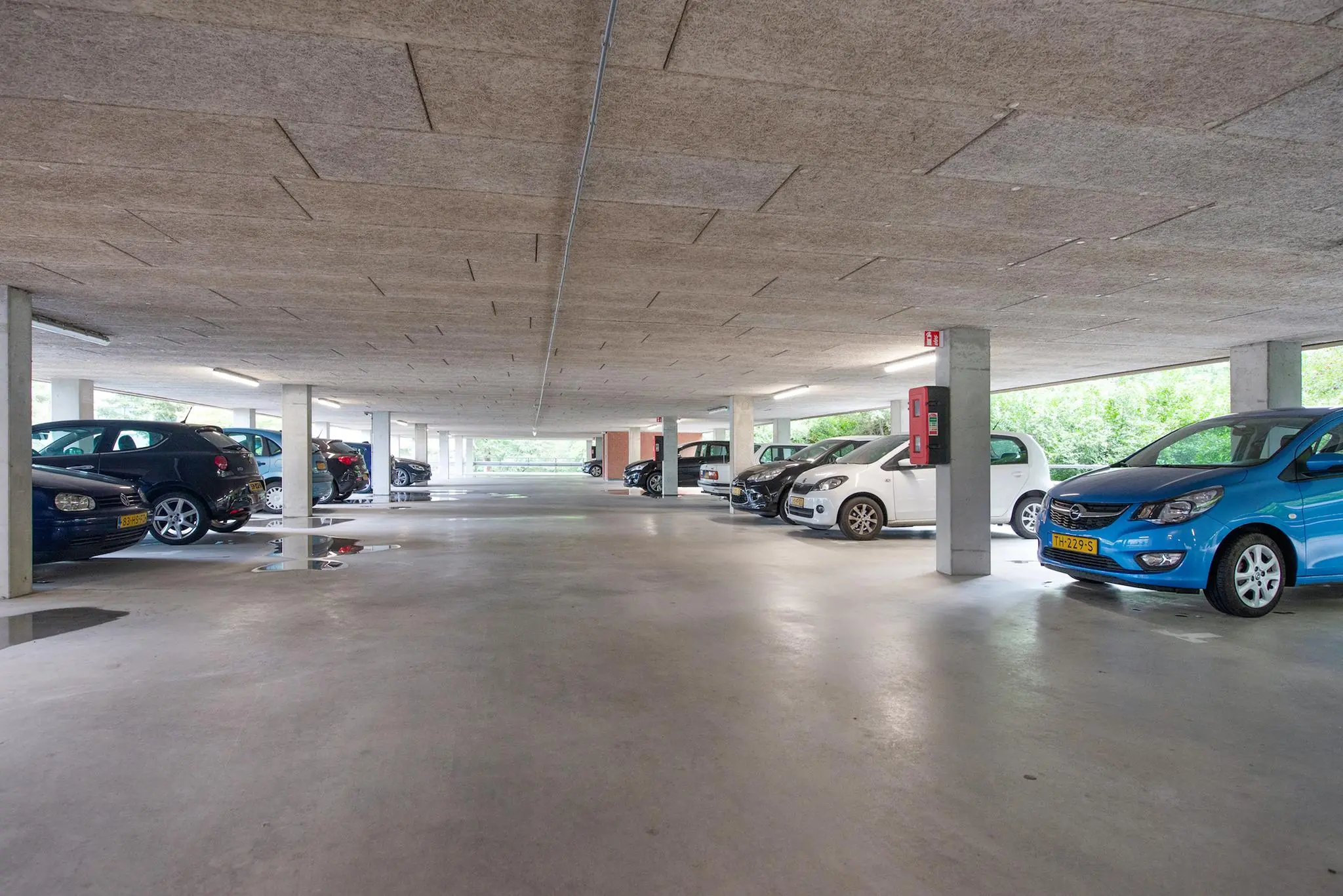Overdekte parkeergarage op Delftechpark met meerdere geparkeerde auto's en betonnen kolommen.