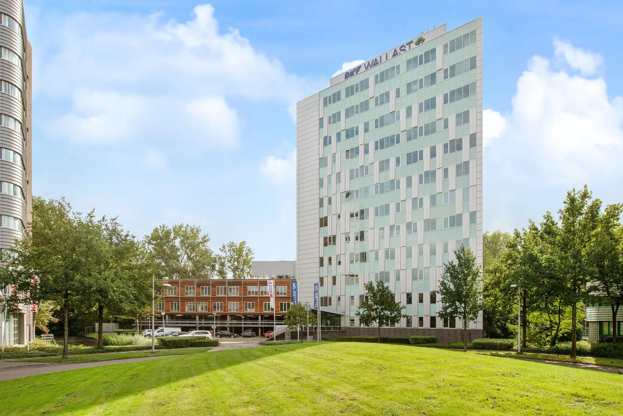 Modern kantoorgebouw van PKF Wallast aan het Delftechpark met omliggend groen en parkeerterrein.