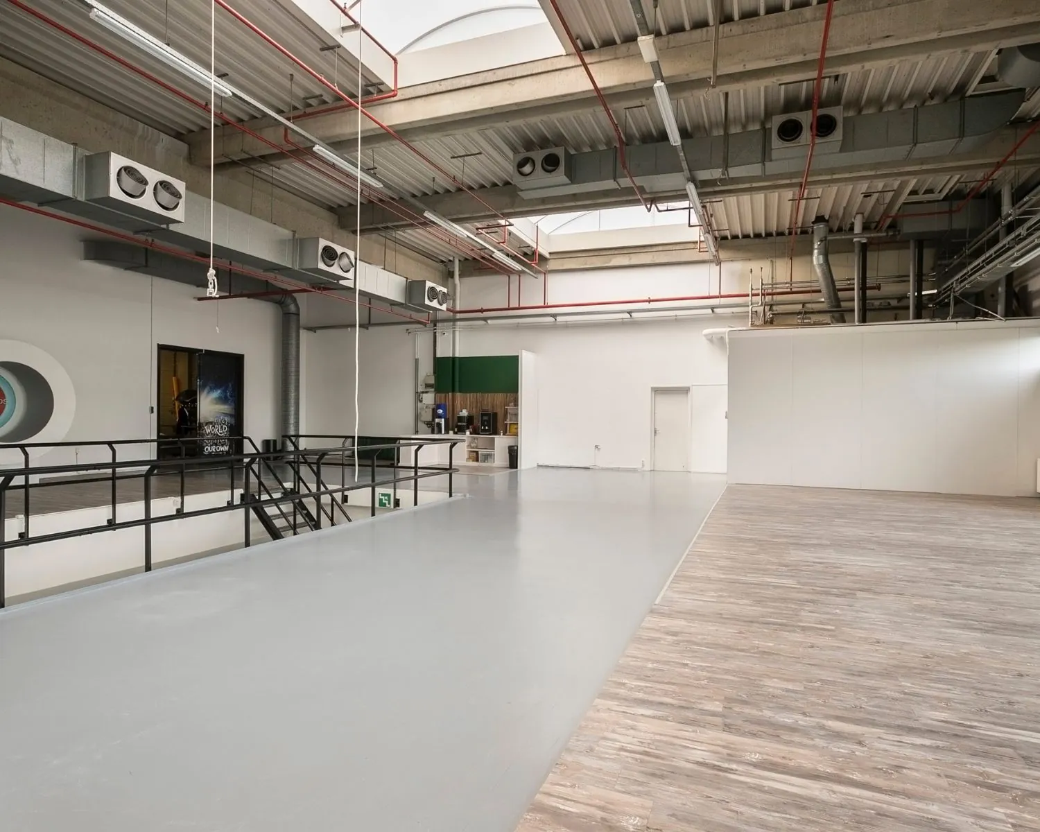 Moderne, industriële kantoorruimte aan de Bolderweg 2 in Almere met hoog plafond, strakke afwerking en een mix van beton- en houtlook vloer.