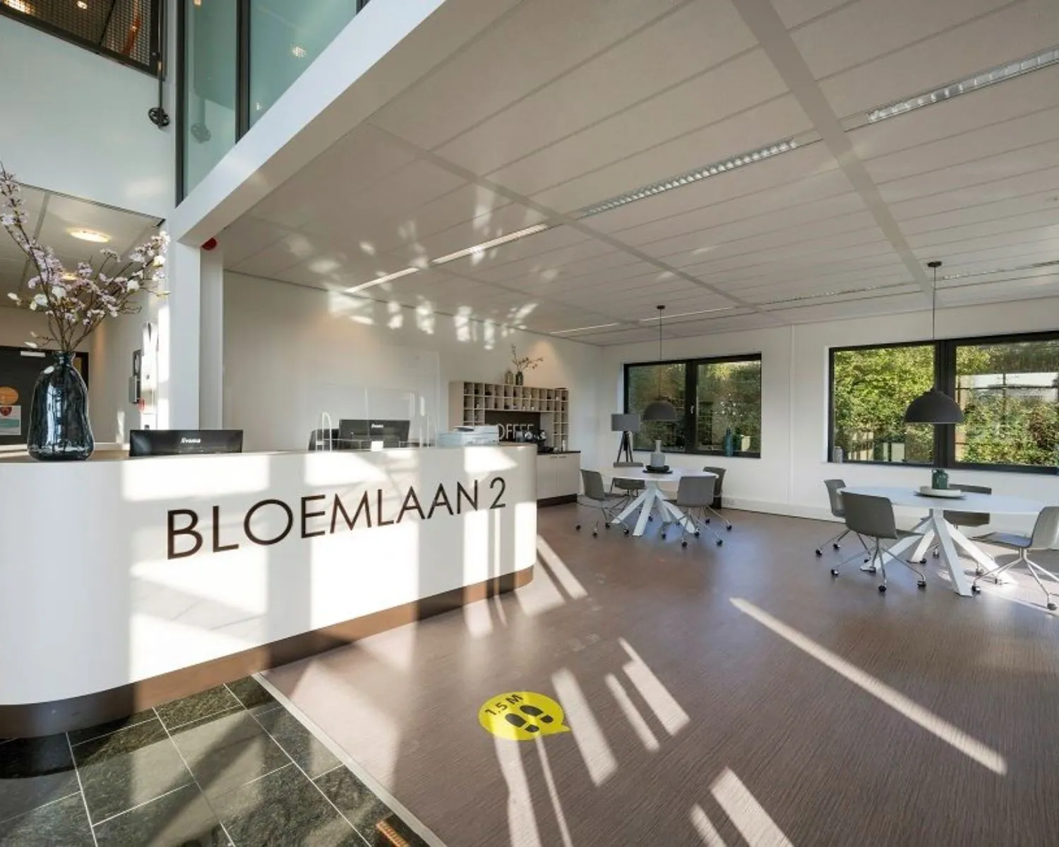 Moderne kantoorruimte met receptiebalie en zithoeken aan de Bloemlaan 2 in Hoofddorp.