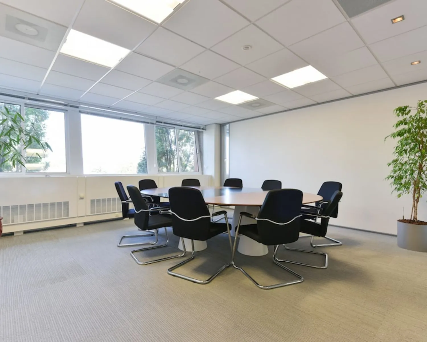 Vergaderruimte met ronde tafel en acht stoelen in een kantoor aan de Treubstraat 1 in Rijswijk.