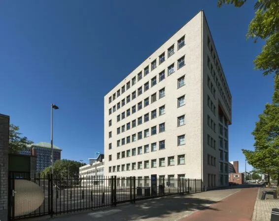Wit bakstenen kantoorgebouw aan de Derkinderenstraat in Amsterdam op een zonnige dag.