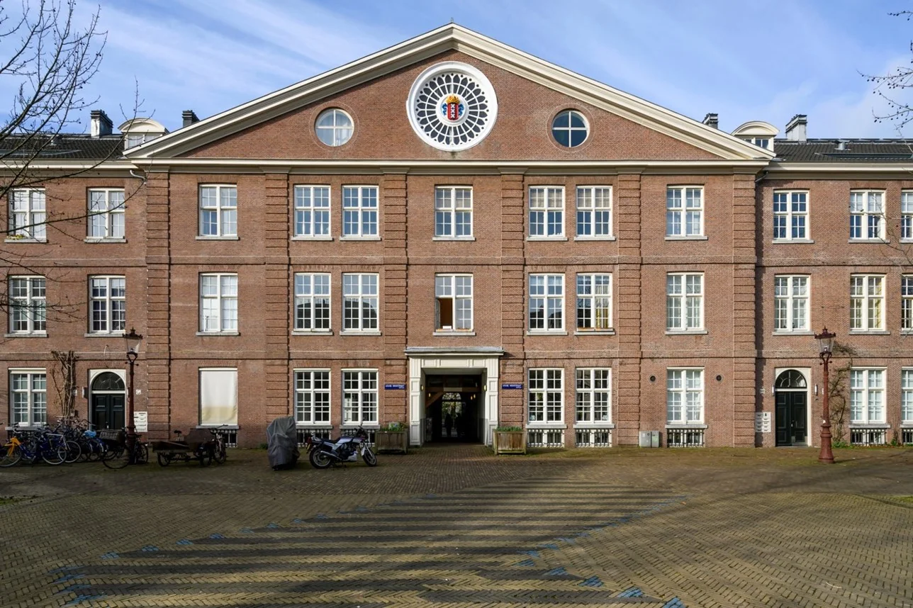 Vooraanzicht van een monumentaal pand aan de Sarphatistraat in Amsterdam met een symmetrische gevel en klassiek metselwerk.