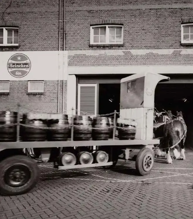 Een paard en wagen met biervaten voor de Heineken brouwerij aan de Ruysdaelkade.