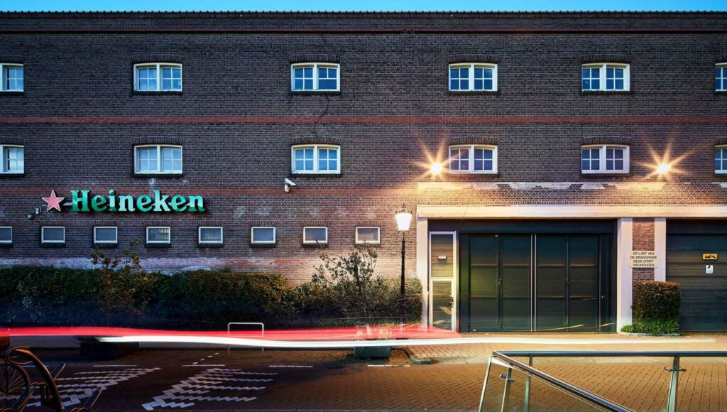 Bakstenen gevel van het Heineken-gebouw aan de Ruysdaelkade bij avondverlichting.
