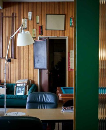 Interieur van een nostalgische ruimte aan de Ruysdaelkade met houten wandpanelen, vintage meubels en decoraties.