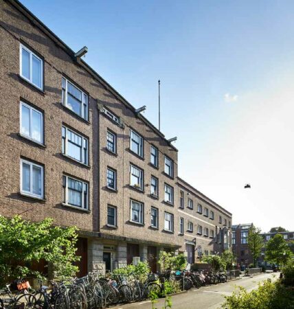 Appartementencomplex aan de Ruysdaelkade in Amsterdam met fietsen geparkeerd langs de stoep op een zonnige dag.