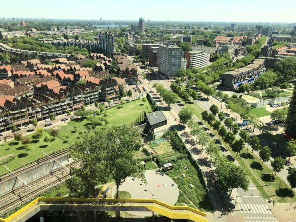 Luchtfoto van het Hofplein in Rotterdam met woonwijken, groenstroken, spoorlijnen en stedelijke infrastructuur.