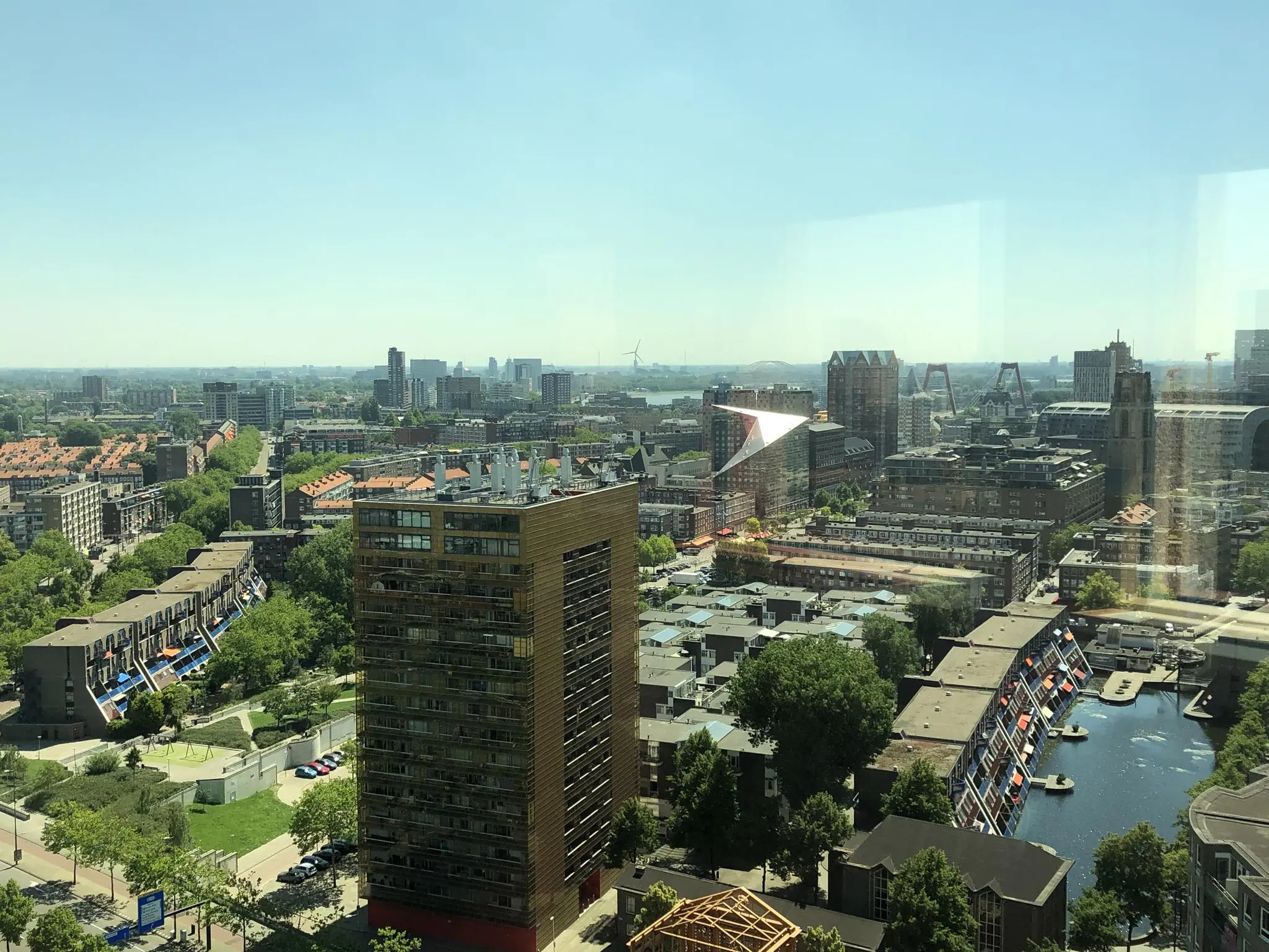 Uitzicht op het Hofplein in Rotterdam met moderne en historische gebouwen, waaronder de opvallende kubuswoningen en de Laurenskerk.