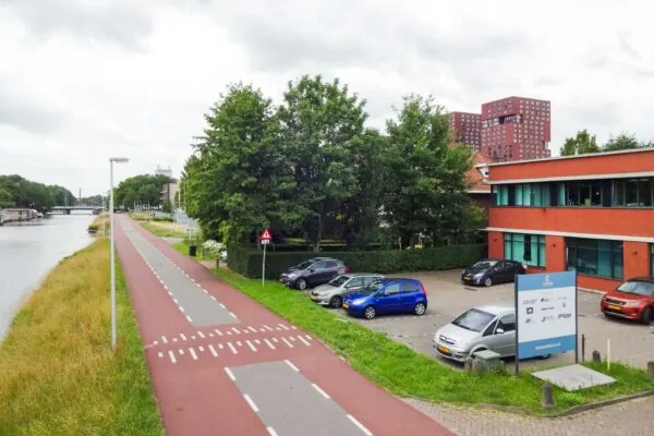 Kantoorpand aan de Kanaalweg in Utrecht met parkeerplaats en aangrenzend fietspad langs het water.