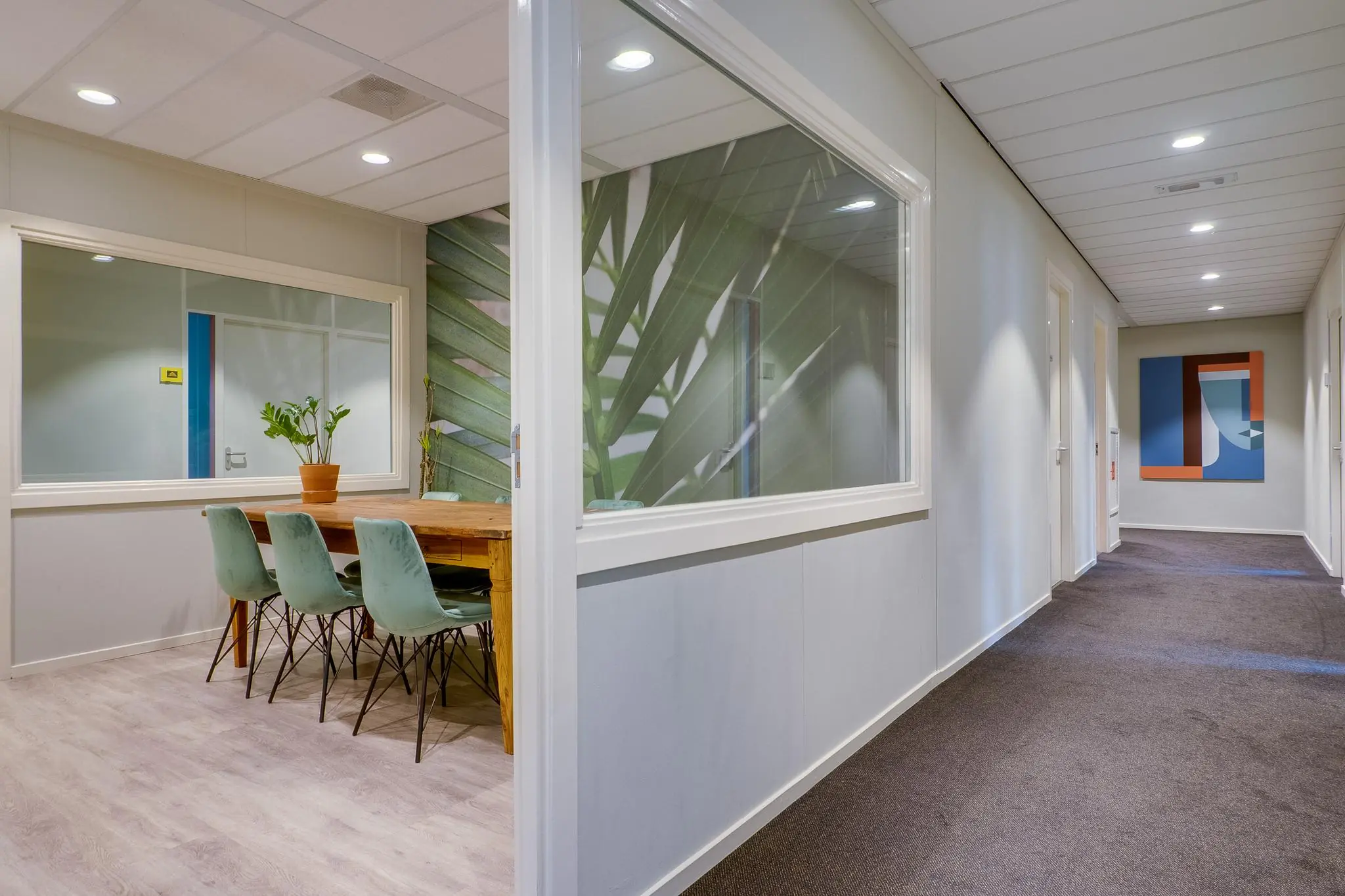 Moderne kantoorruimte aan de Kanaalweg met vergaderruimte, planten en kunst aan de muur.