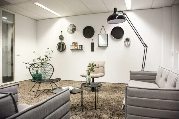 Moderne wachtruimte aan de Meidoornkade met strakke meubels, muurdecoratie en warme verlichting.