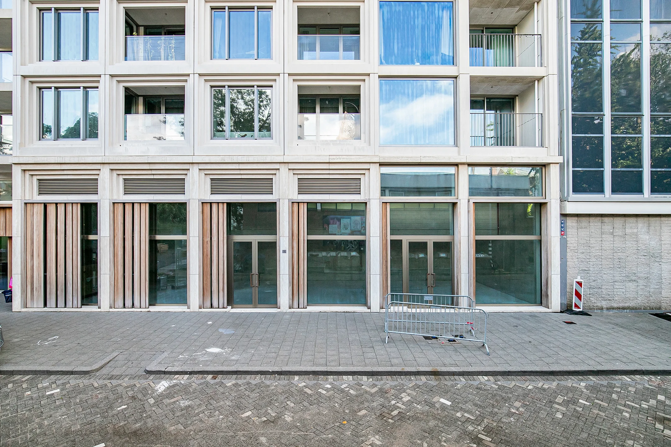 Modern ground-floor commercial space with large glass doors and wooden panel accents in the Baan building.