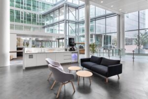 Moderne en lichte ontvangstruimte in Kennedy Tower aan het Kennedyplein 200 in Eindhoven met zithoek, koffiecorner en grote glazen gevels.