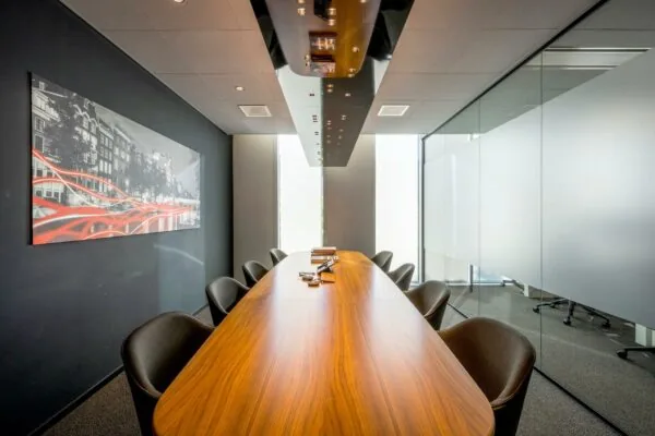 Vergaderruimte in Hoekenrode met een lange houten tafel, moderne stoelen en glazen wanden.
