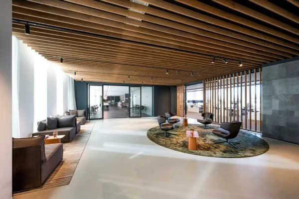 Moderne wachtruimte in kantoorgebouw Hoekenrode met designmeubilair en houten plafondaccenten.