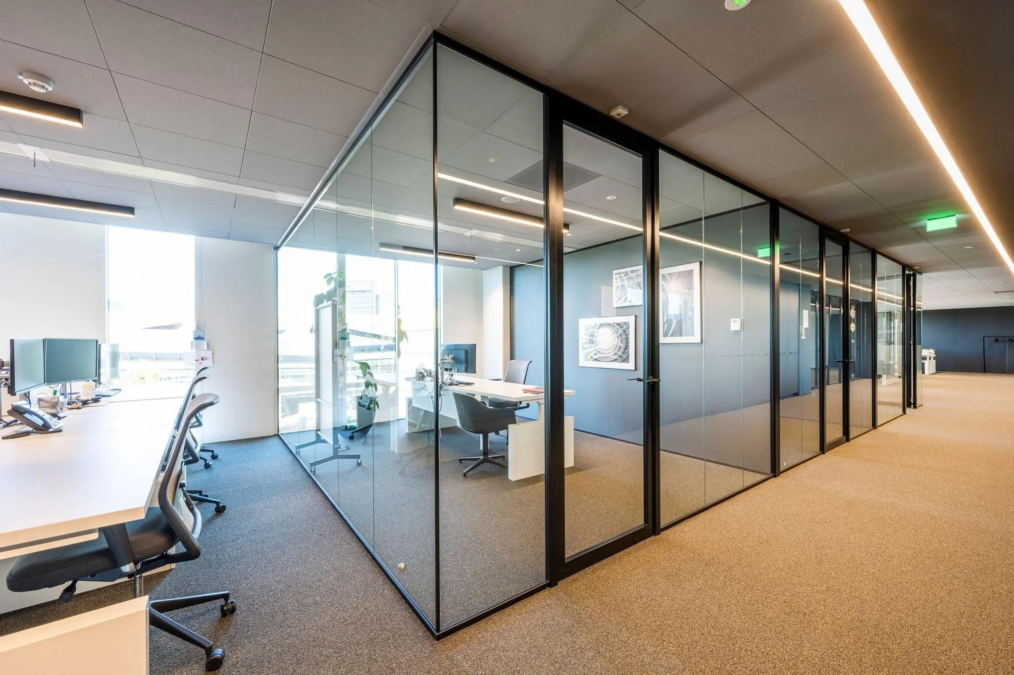 Modern kantoorinterieur in Hoekenrode met glazen vergaderruimtes en open werkplekken.