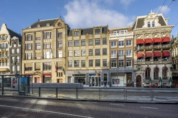 Rij historische en moderne gebouwen aan het Rokin in Amsterdam met winkel- en horecapanden op de begane grond.