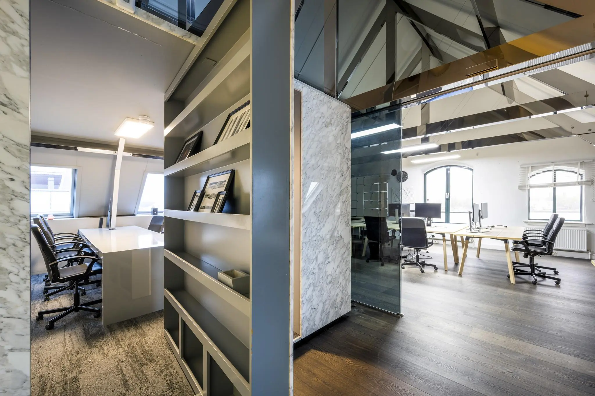 Modern kantoorinterieur aan de De Ruijterkade met vergaderruimte, werkplekken en open houten dakconstructie.