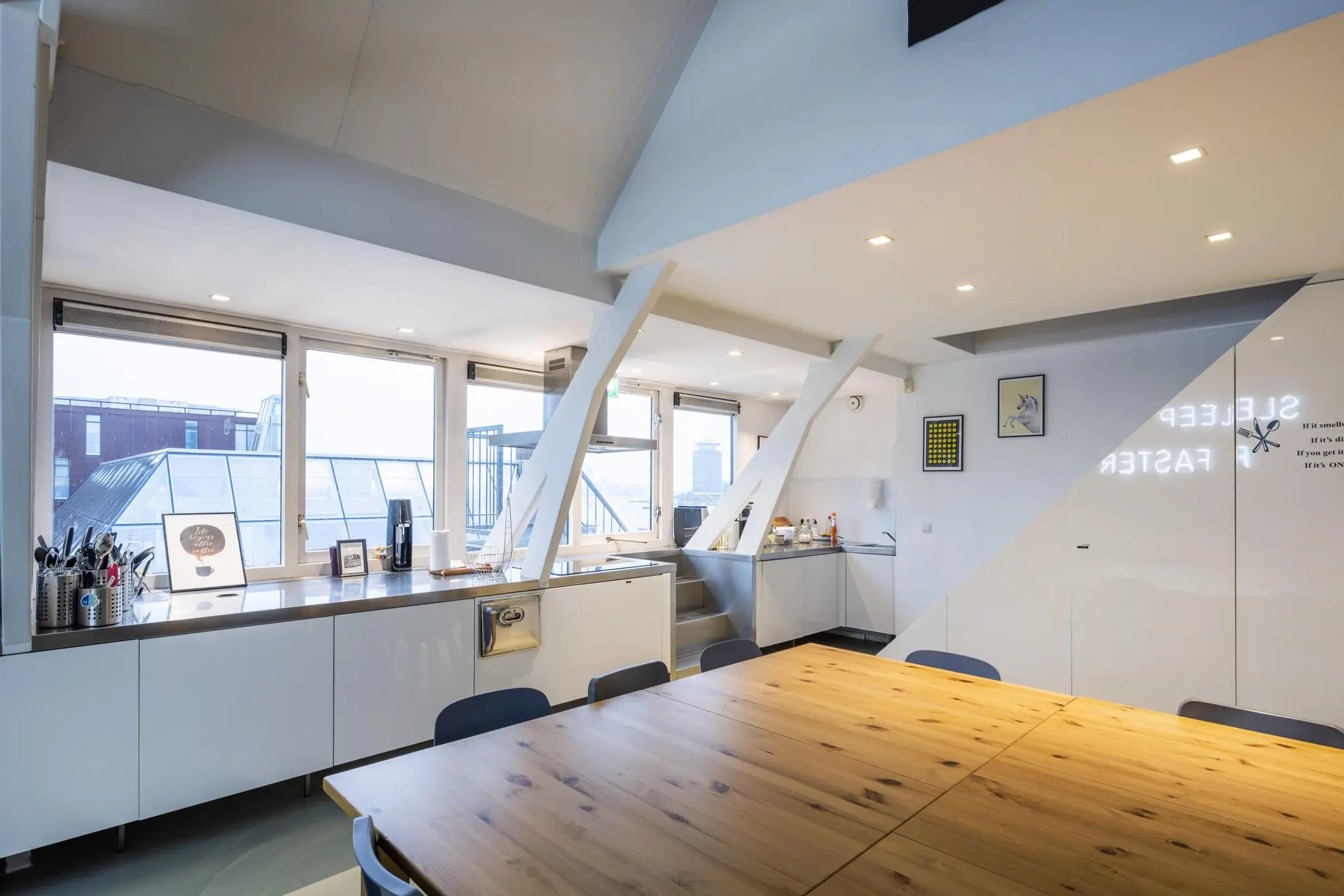 Moderne, lichte keuken en eetruimte met houten tafel aan de De Ruijterkade.